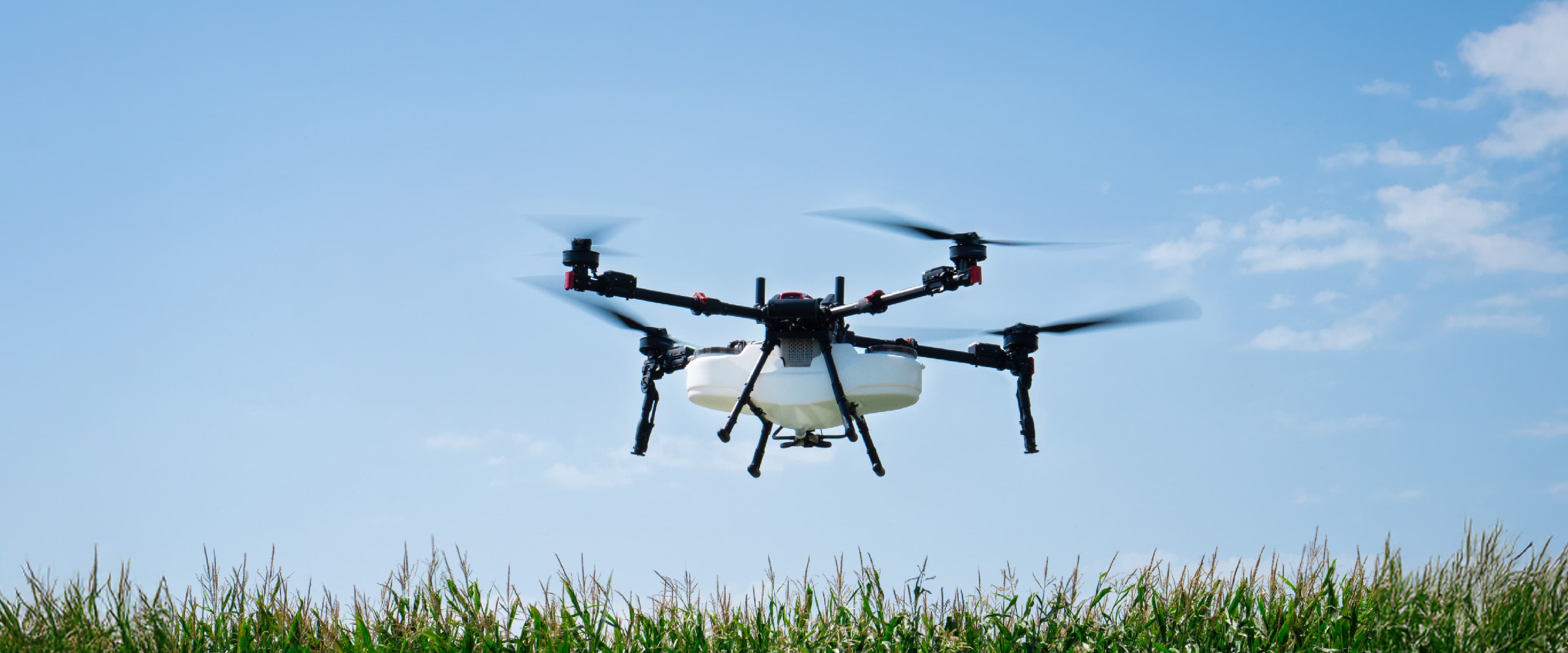 An XAG agricultural drone on the ground with its tank and spray arms extended