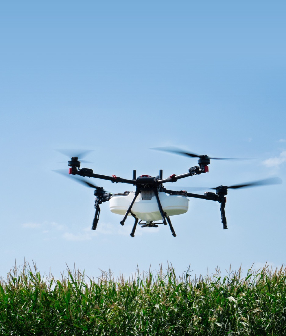 An XAG agricultural drone in flight above a corn field